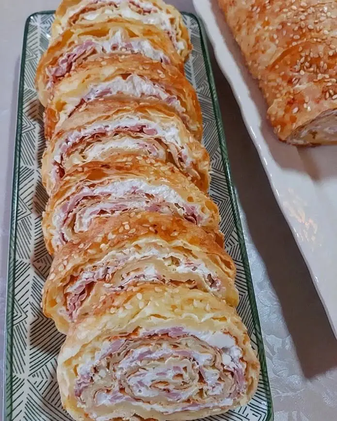 Slani rolat od kora za pitu, posut susamom i spremljen za serviranje