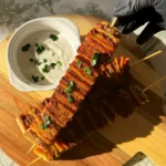 Tortilja kebab ražnjići posluženi na drvenoj dasci uz kremasti bijeli umak i svježi peršin, sočno pečeni i spremni za posluživanje