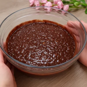 Gusta čokoladna smjesa s komadićima oraha u staklenoj zdjeli prije pečenja kolača
