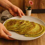 Svježe pečene tortilje od tikvice na bijelom tanjiru koje se drže u rukama bez laka na noktima